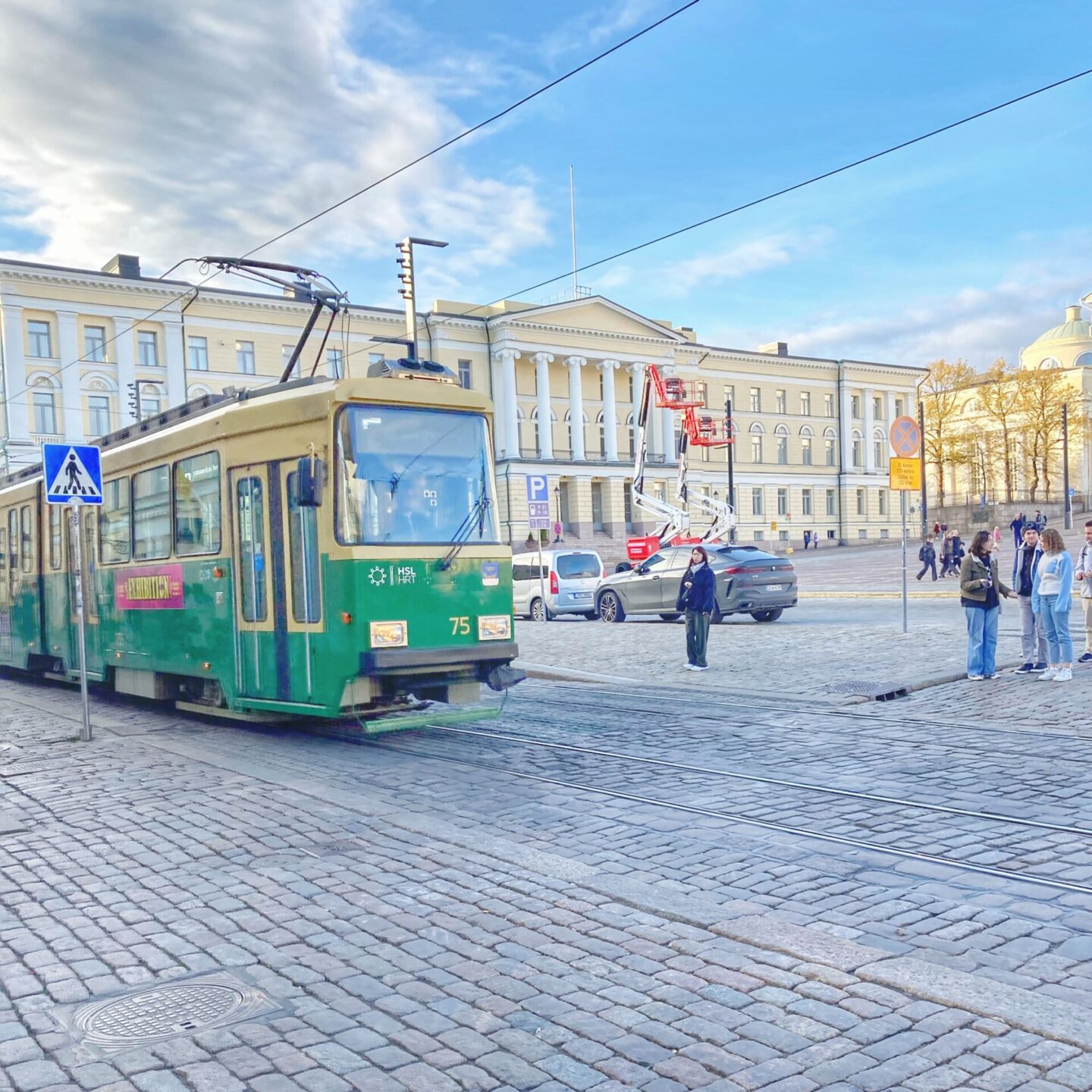 A green and yellow tram in Senate Square, Helsinki